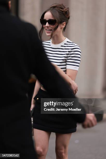 Alba Baptista seen wearing a black and white striped shirt, dark shades and a black mini skirt before the Miu Miu show on March 07, 2023 in Paris,...