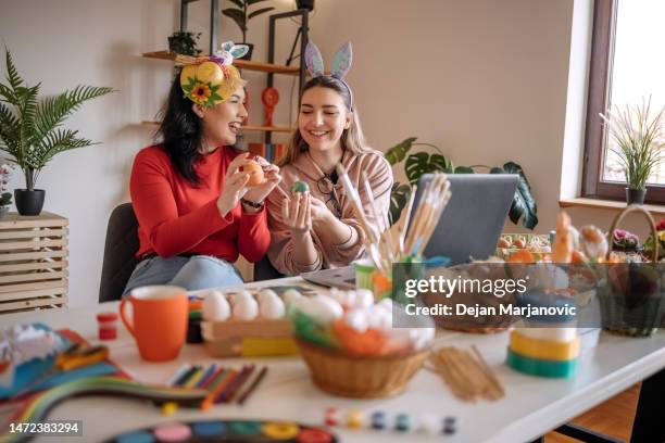 duas amigas jovens se divertindo em casa preparando a decoração da páscoa - easter basket - fotografias e filmes do acervo
