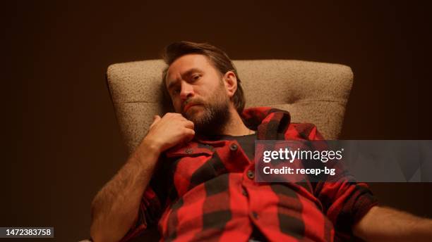 studio portrait of handsome man sitting on sofa - special jurisdiction for peace stock pictures, royalty-free photos & images