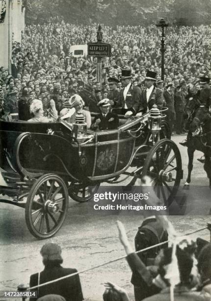 'Victory Drive - 8th June, 1946', 1947. The future Queen Elizabeth II, with her mother Queen Elizabeth and father King George VI, waving at crowds...