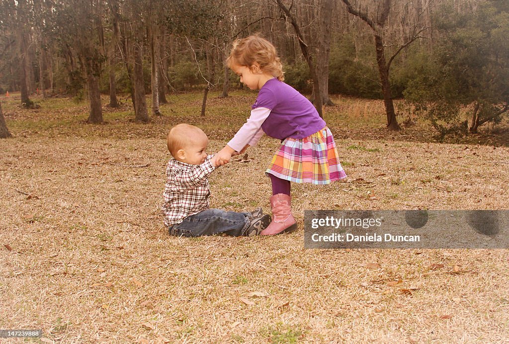 Girl helping boy in standing up