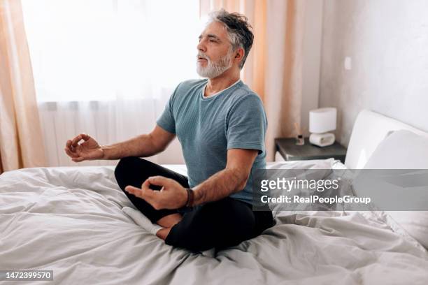 den stress ausdehnen. wie dieser mann yoga im bett praktiziert - deep breathing stock-fotos und bilder