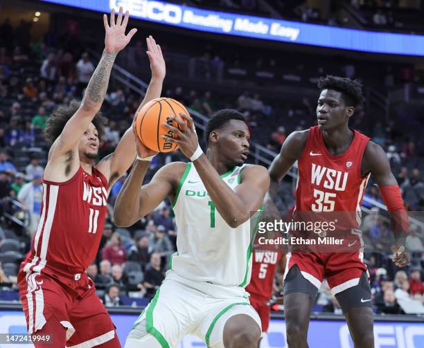 Faly Dante of the Oregon Ducks looks to pass against the under pressure from DJ Rodman and Mouhamed Gueye of the Washington State Cougars in the...