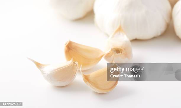 close up on a clove of garlic and garlic bulbs - garlic clove stock pictures, royalty-free photos & images