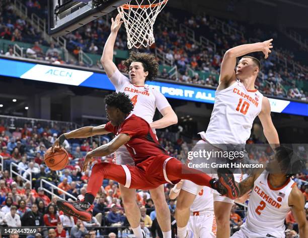 Jarkel Joiner of the North Carolina State Wolfpack looks to pass as he drives agianst Ian Schieffelin, Ben Middlebrooks and Dillon Hunter of the...