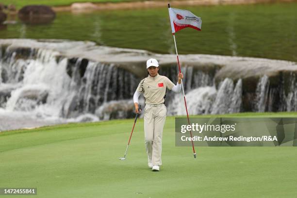 Yujie Liu of China removes the flagstick during Day Two of The Women's Amateur Asia-Pacific Championship on The New Course at The Singapore Island...