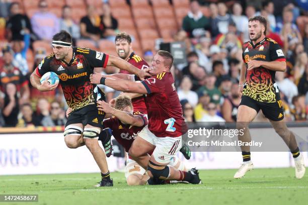 Luke Jacobson of the Chiefs fends off the tackle from Ethan de Groot of the Highlanders during the round three Super Rugby Pacific match between...