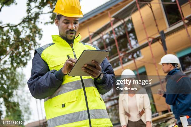 bauunternehmer in schutzweste mit tablet - reflektor stock-fotos und bilder