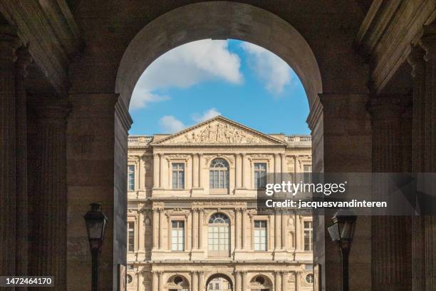 una pequeña parte del louvre (parís, francia), vista a través de una de sus muchas puertas - louvre fotografías e imágenes de stock