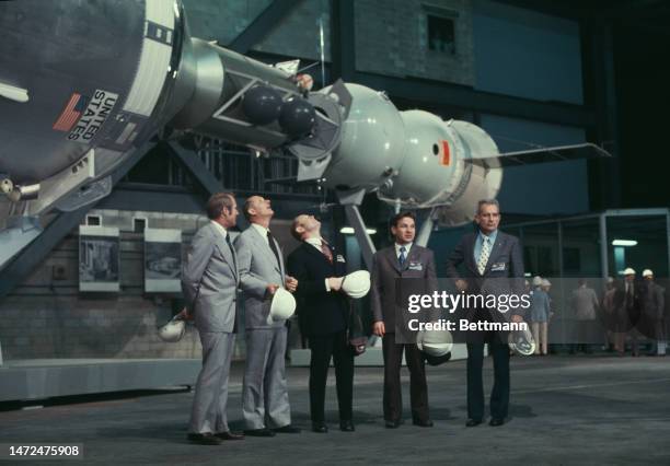 The five-man crew of the Apollo-Soyuz Test Mission poses beneath a mock-up of the two spacecraft at the Kennedy Space Center in Cape Canaveral,...