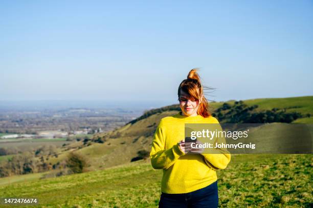 young woman using phone in south downs national park - south park stock pictures, royalty-free photos & images