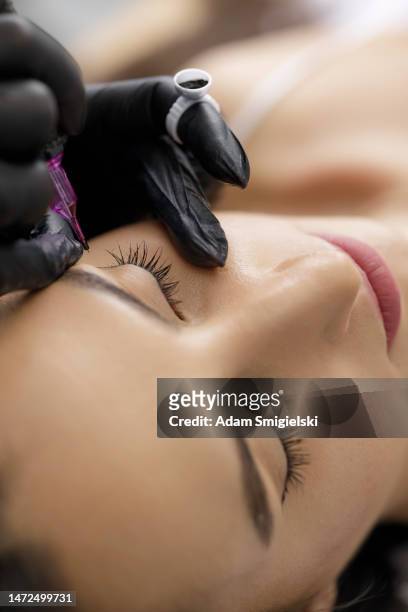 permanent eye make-up application by a make-up artist in a beauty salon - adam pretty stockfoto's en -beelden