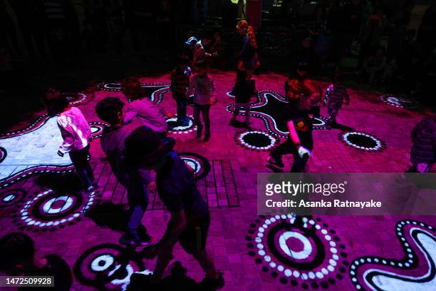 Children are seen running around the illuminations during the Aboriginal light festival titled Grounded presented by Parrtjima at Federation Square...