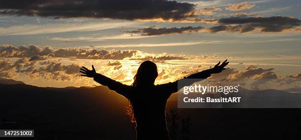 a silhouette of a woman with her arms open in the sunset - god is love stock pictures, royalty-free photos & images