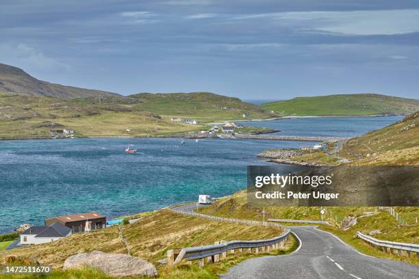 view of road heading to causeway which connects barra to vatersay in the background, barra island, outer hebrides, scotland, united kingdom - barra scotland stock pictures, royalty-free photos & images