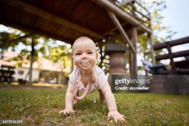 happy baby girl crawling during spring day at the park. - crawling stock pictures, royalty-free photos & images