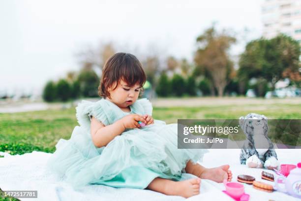 little baby girl laying with toys in public park - tiger girl stock pictures, royalty-free photos & images