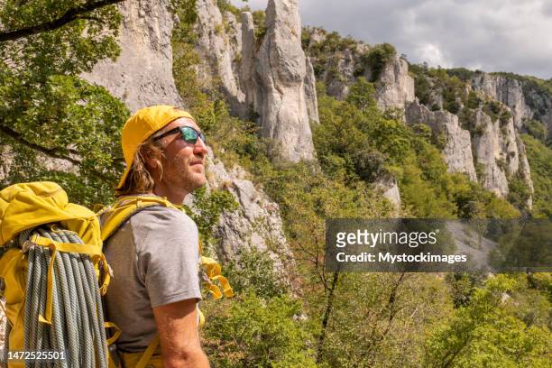 male mountain climber looks at pinnacle rocks and contemplates nature - istria stock pictures, royalty-free photos & images