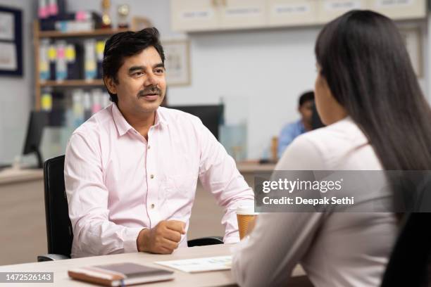 female client consulting with a bank teller at bank counter. stock photo - bank manager imagens e fotografias de stock