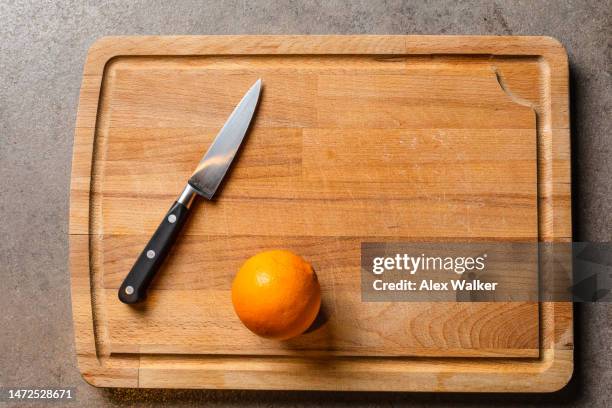 orange fruit and kitchen knife on wooden chopping board - five a day stock pictures, royalty-free photos & images