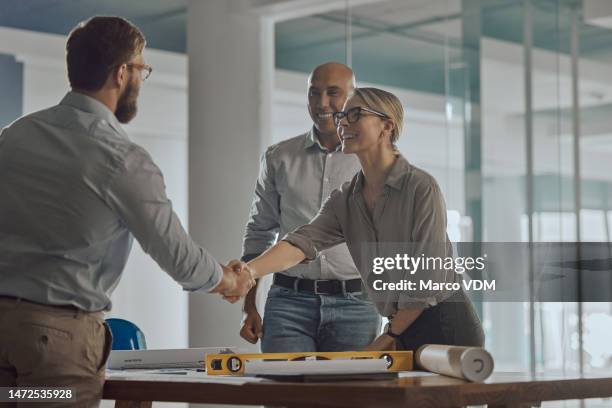 architect woman, handshake and business people in office for agreement, deal and real estate planning. man, architecture agency and shaking hands for property vision, teamwork and goals for building - beef stockfoto's en -beelden