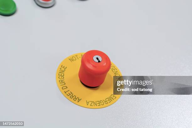 stop button and the hand of worker about to press it. emergency stop button. big red emergency button or stop button for manual pressing. - big red button stockfoto's en -beelden