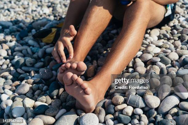 teenager lying on the sea beach sunbathing on pebbles - hot boy body stock-fotos und bilder