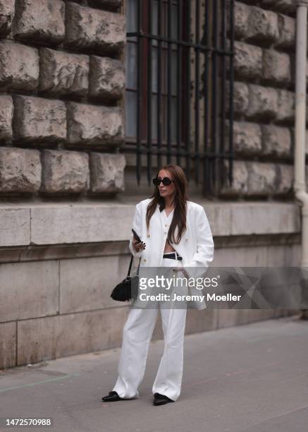 Chloe Harrouche seen wearing a full white outfit, white blazer jacket, white wide pants, black shoes, black belt and Hermes crossbody bag, sunglasses...