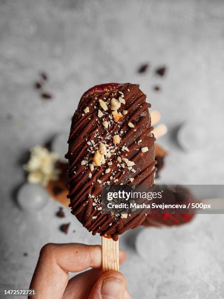 cropped hand holding ice cream - almonds and chocolate stock-fotos und bilder