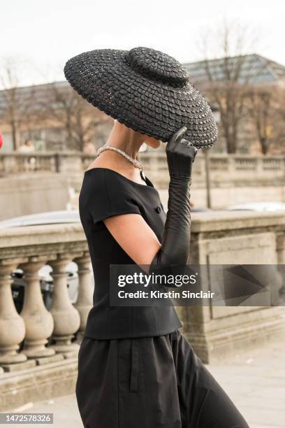 Sabina Jakubowicz wears a Dior hat and top with Balenciaga trousers outside the Dior show on February 28, 2023 in Paris, France.