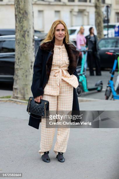 Blanca Miro Scrimieri wears beige checkered pants, belted jacket, coat, black Chanel bag, shoes outside Chanel during Paris Fashion Week - Womenswear...