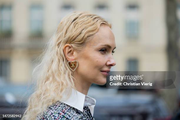 Olga Karput wears heart shaped earring with logo outside Chanel during Paris Fashion Week - Womenswear Fall Winter 2023 2024 : Day Nine on March 07,...