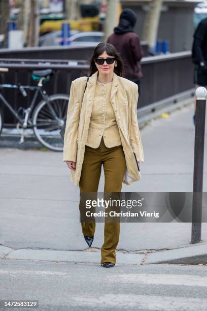 Kat Collings Wolf wears beige jacket, button up top, khaki pants, black pointed heels outside Chanel during Paris Fashion Week - Womenswear Fall...