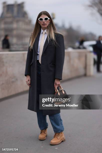 Veronika Heilbrunner is seen wearing a grey coat, white blouse, blue jeans, brown Timberland boots and white sunglasses and a mini Louis Vuitton...