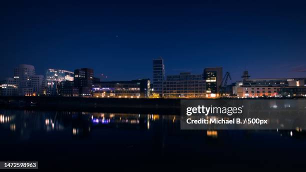 view of illuminated buildings against sky at night,germany - schwache beleuchtung stock-fotos und bilder