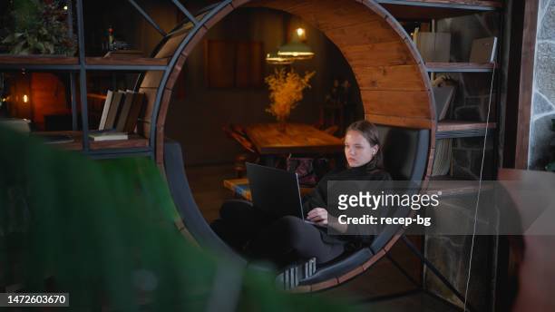 woman using laptop in cafe - teleworking hipster stock pictures, royalty-free photos & images