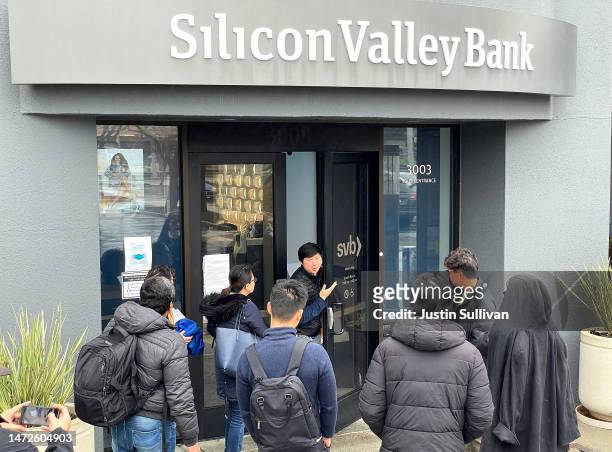 Worker tells people that the Silicon Valley Bank headquarters is closed on March 10, 2023 in Santa Clara, California. Silicon Valley Bank was shut...