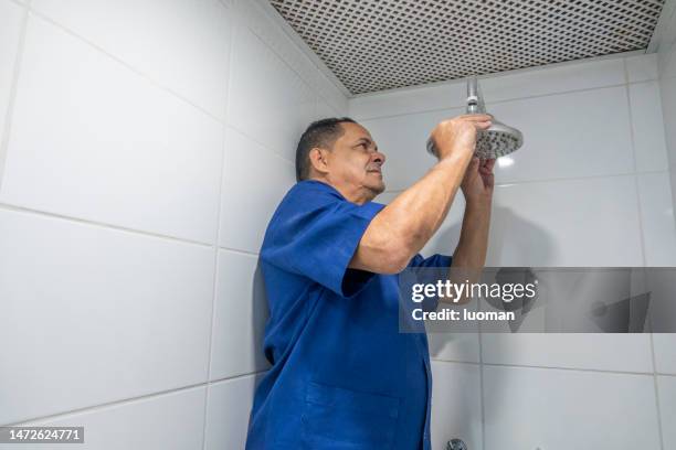 plumber repairing an apartment shower - leaking ceiling stock pictures, royalty-free photos & images