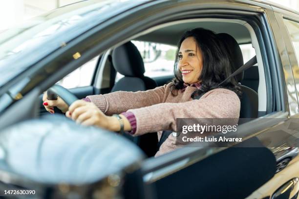 woman sitting in new car and checking the comfort in a showroom - customer test drive stock pictures, royalty-free photos & images