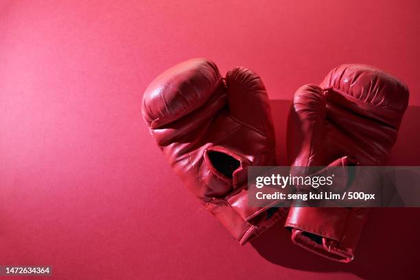 old red boxing hand glove against red background,malaysia - boxer knockout stock pictures, royalty-free photos & images