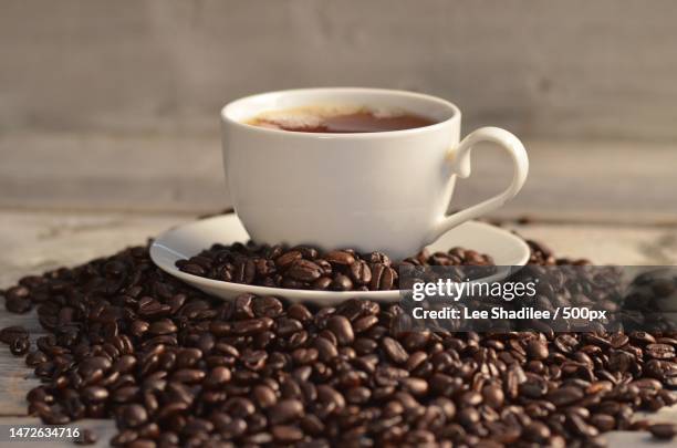 close-up of coffee cup with beans on table,indonesia - turkish coffee drink stock pictures, royalty-free photos & images