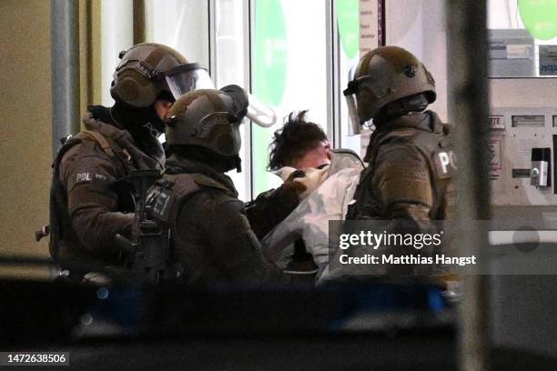 Heavily-armed police arrest and remove a suspect from a pharmacy where the perpetrator was reportedly holding a hostage on March 10, 2023 in...