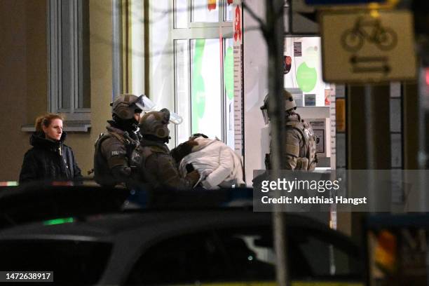 Heavily-armed police arrest and remove a suspect from a pharmacy where the perpetrator was reportedly holding a hostage on March 10, 2023 in...