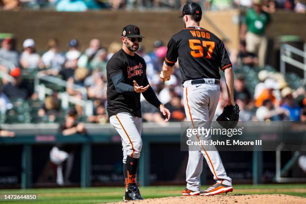 Gabe Kapler of the San Francisco Giants takes the ball from Alex Wood during the third inning o the Spring Training game against the Colorado Rockies...