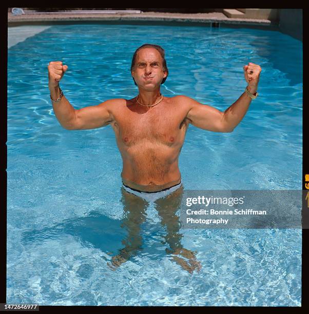 Actor and comedian Sid Caesar poses standing in his pool with flexed arms, cheeks puffed and a look of concentration in Los Angeles in 1984. He wears...