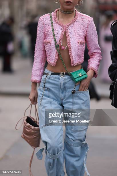 Niki Wu Jie seen wearing a tweed pink cropped sequins jacket, oversized jeans, a shiny bag and a green leather bag and white heels before the Chanel...