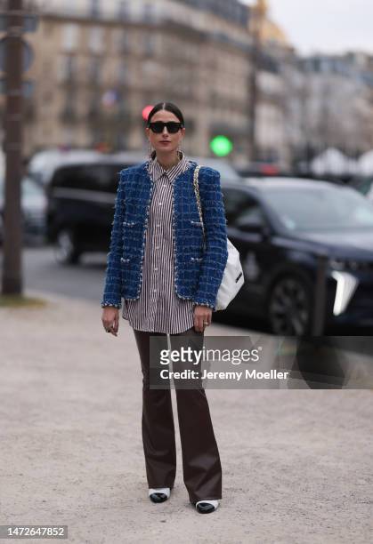Julia Haghjoo seen wearing a blue tweed jacket, a striped blouse, brown leather pants a white bag, black shades and black and white ballet flats...