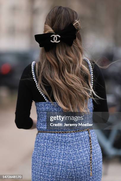 Paola Alberdi seen wearing a blue tweed jumpsuit, a black turtle neck sweater, a black belt bag and a black and beige bag by Chanel, black shades and...