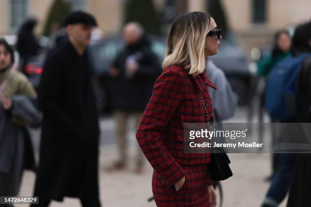 Candela Pelizza seen wearing a matching red and black checked set with a blazer and a skirt, black shades, black heels and a black bag before the...