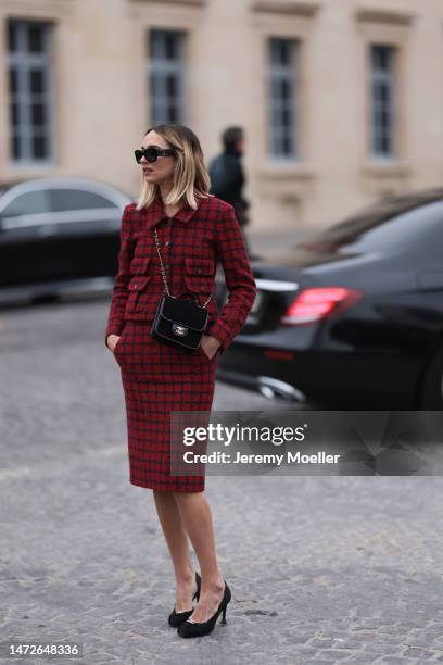 Candela Pelizza seen wearing a matching red and black checked set with a blazer and a skirt, black shades, black heels and a black bag before the...